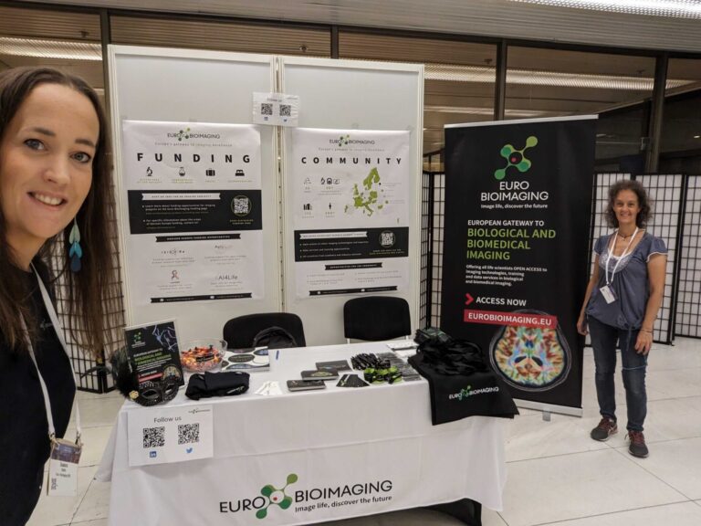 Euro-BioImaging booth at a conference, featuring Susanne Vainio (left) and Alessandra Viale (right)